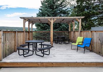 Picnic patio on wooden deck with tables and chairs
